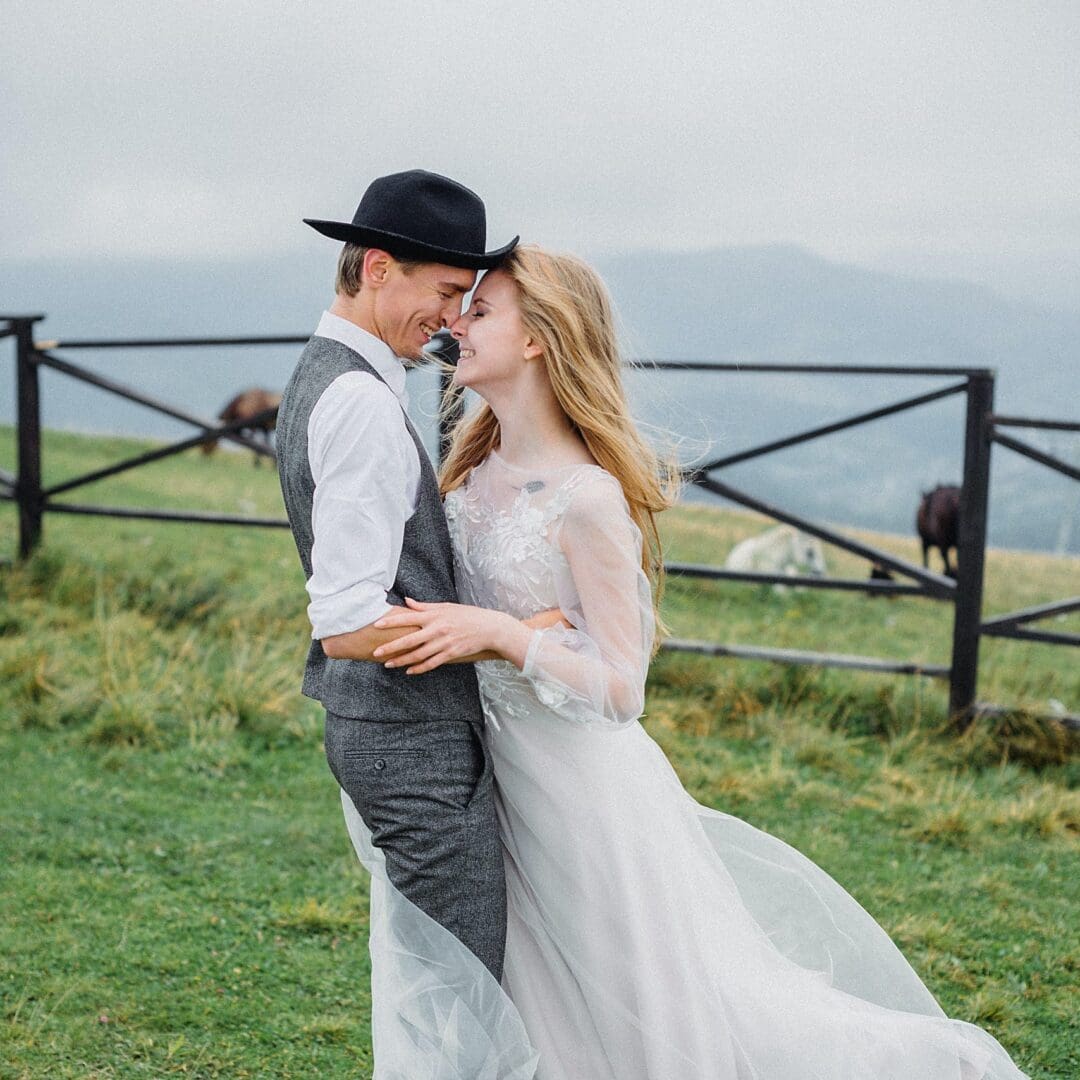 A man and woman in wedding attire embracing.