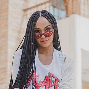 A woman with long black hair wearing sunglasses.