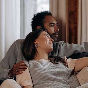 A man and woman sitting on the couch together.